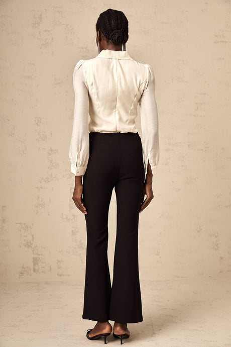 Black flared trousers with decorative bow detail at waist