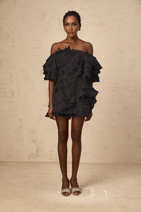 Black mini dress with asymmetric design featuring cerise flounce detail