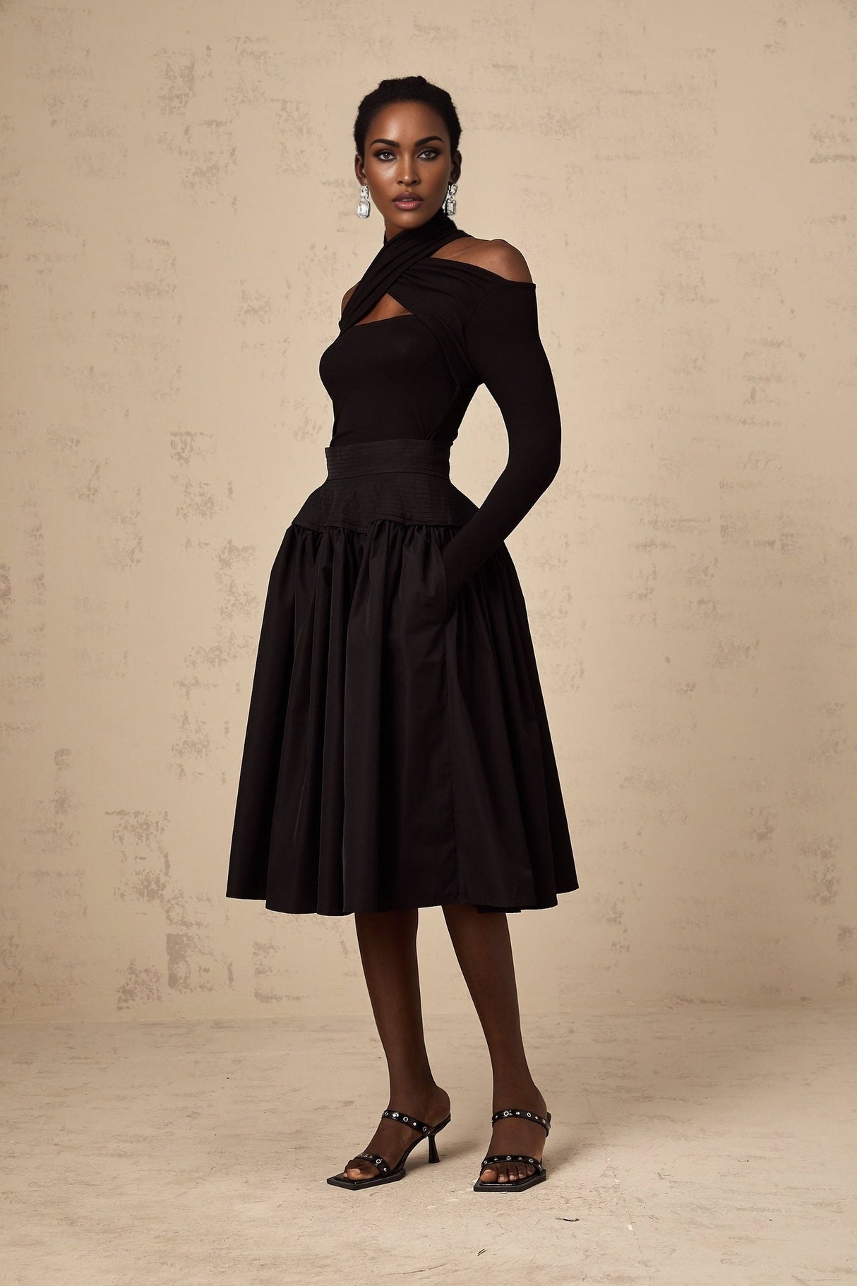 Black pleated midi skirt with flared silhouette named Pauline