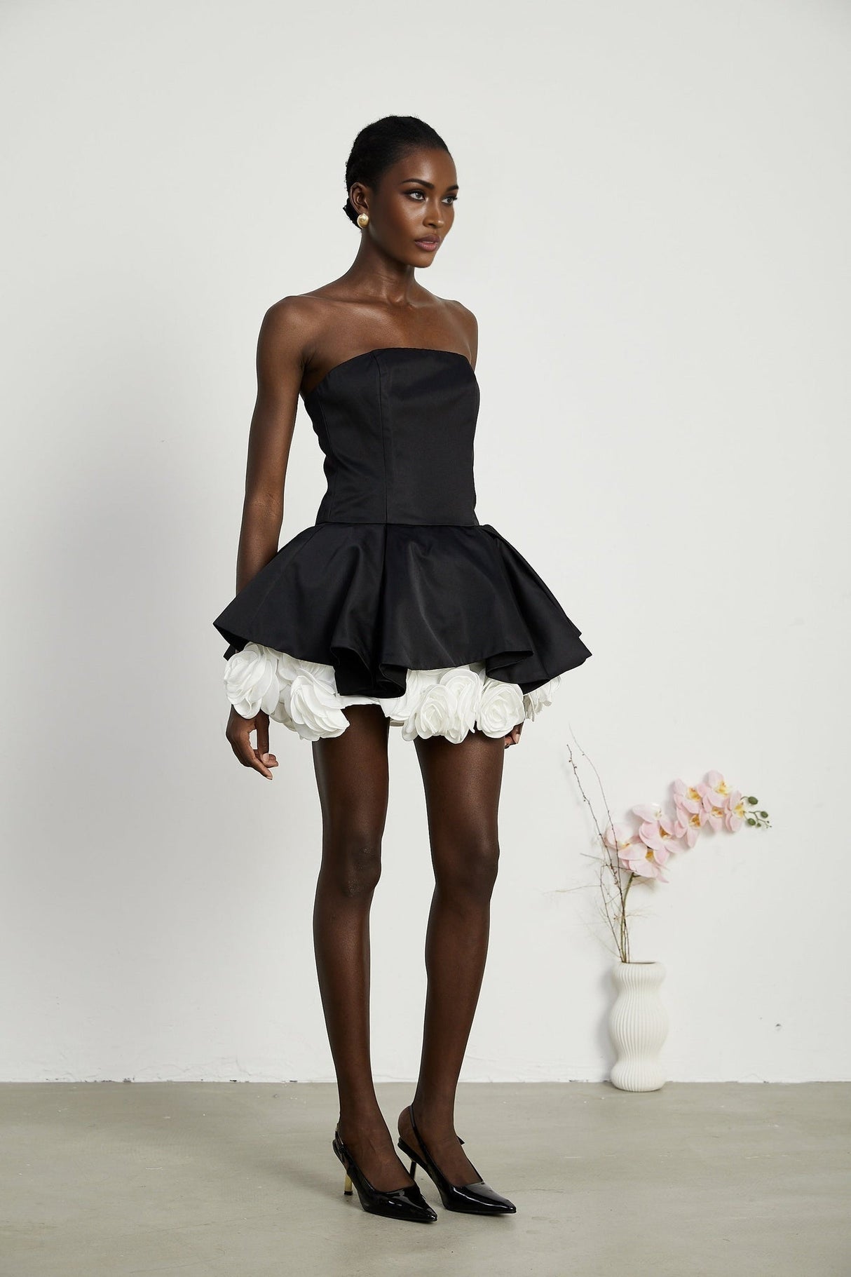 Black strapless mini dress with corset design and petal details called Lucie