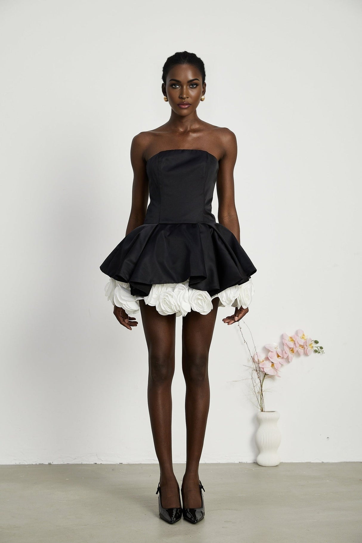 Black strapless mini dress with corset style and petal details named Lucie