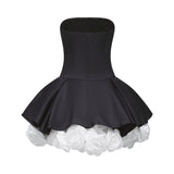Black strapless mini dress with corset style bodice and floral petal details named Lucie