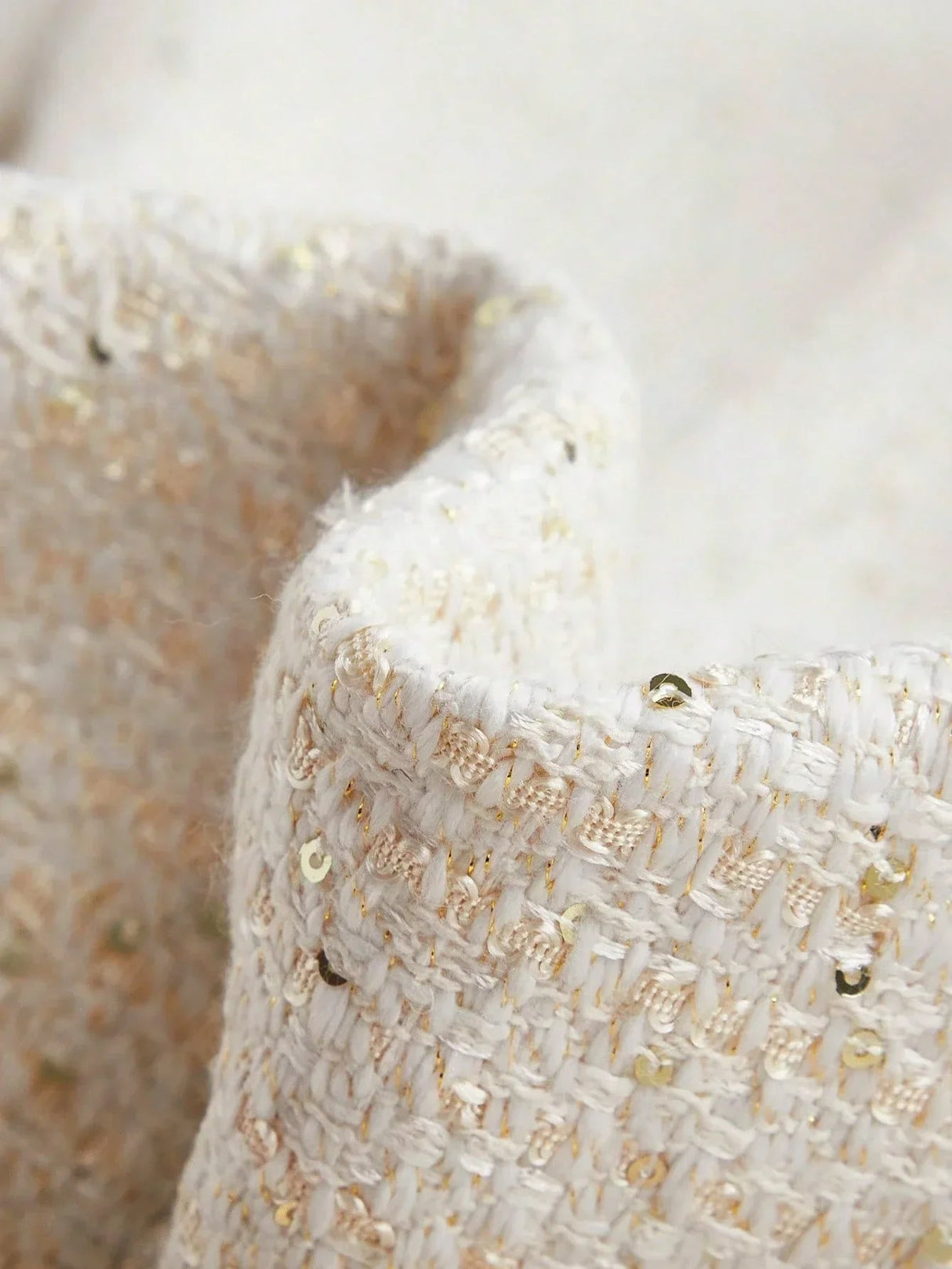 This elegant dress features a soft white fabric adorned with delicate golden threads and shimmering sequins, creating a.