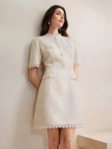 This elegant beige dress features a fitted silhouette with short sleeves and decorative buttons, exuding a chic vintage.