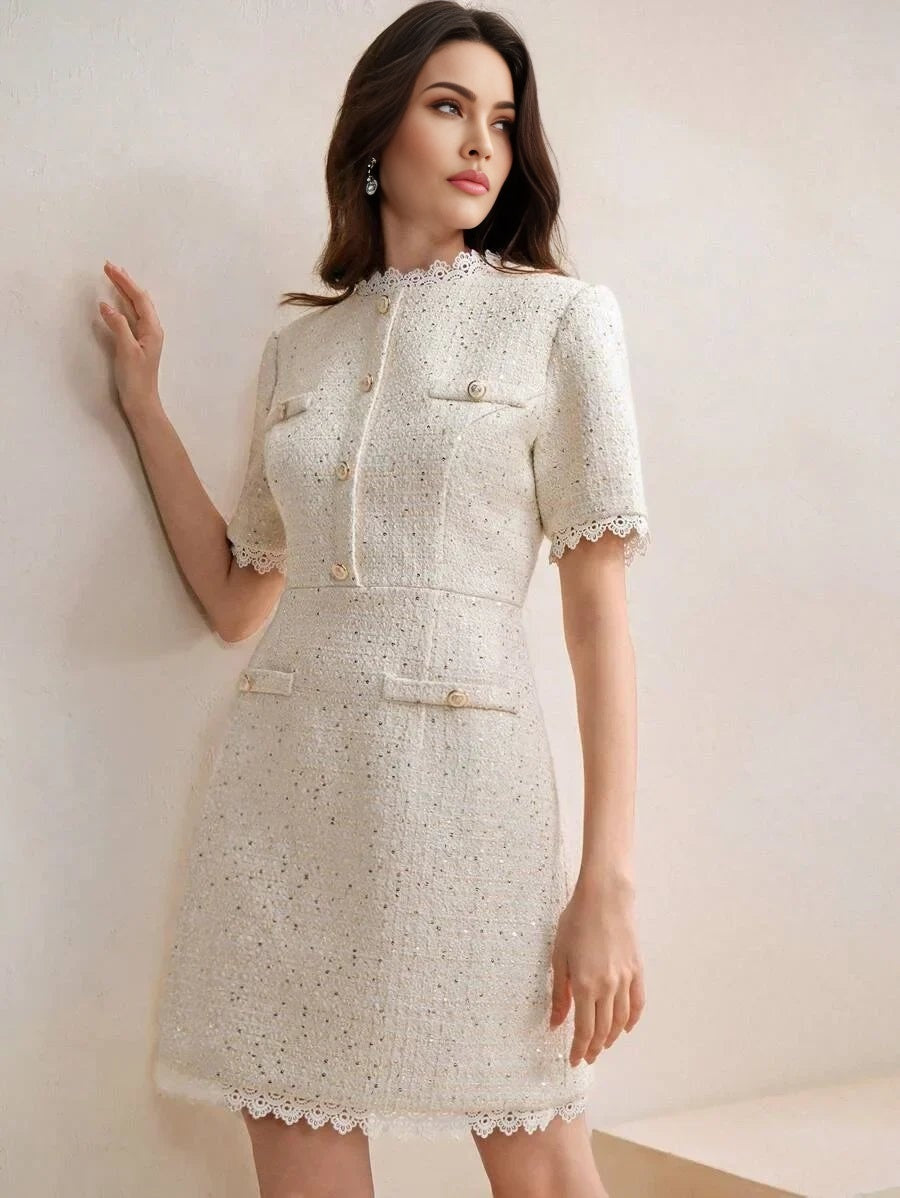 This chic white dress features a stylish, structured fit with short sleeves and delicate lace trim at the collar and hem..