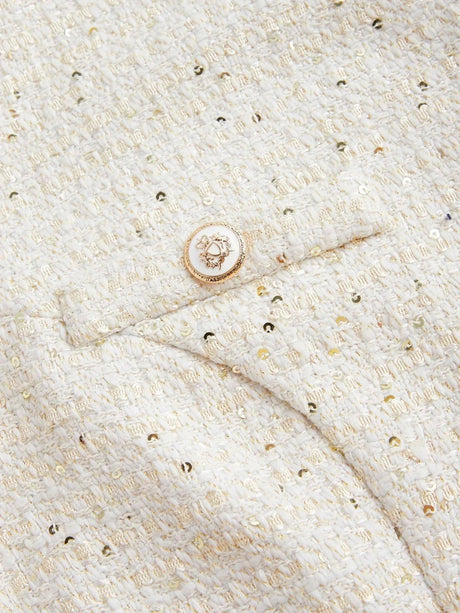 This elegant dress features a soft ivory hue with a textured, metallic woven fabric, adding a touch of shimmer. Designed for.
