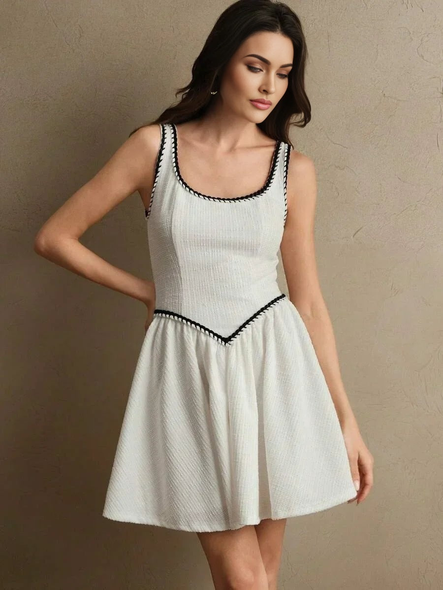 This charming white dress features a flattering fit-and-flare silhouette, accentuated by delicate black trim along the.