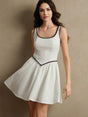 This charming white dress features a playful fit-and-flare silhouette, accentuated by a delicate black trim along the.