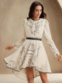 Embrace elegance with this cream long-sleeve dress adorned with delicate floral embroidery, highlighting a fitted bodice.
