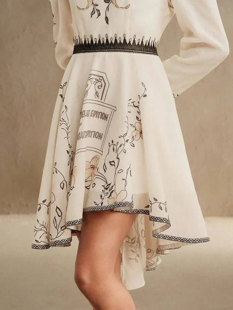 This elegant cream dress features delicate floral illustrations and a chic asymmetric hem, adding a playful touch to its.