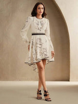 Elevate your wardrobe with this elegant white dress, adorned with delicate floral embroidery and a chic high-low hem. The.