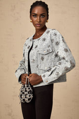 Denim jacket in blue with studded sun design and decorative elements on front