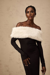 Elegant black midi dress with faux fur trim and offshoulder neckline worn by model against plain background