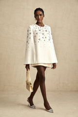 Elegant white jacket with cape design featuring ornate embellishments and beaded details