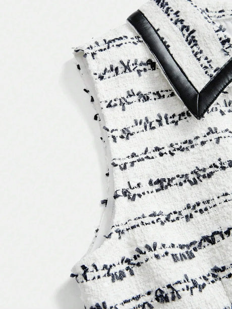 This chic sleeveless dress features a textured white fabric adorned with elegant navy stripes, creating a striking contrast..
