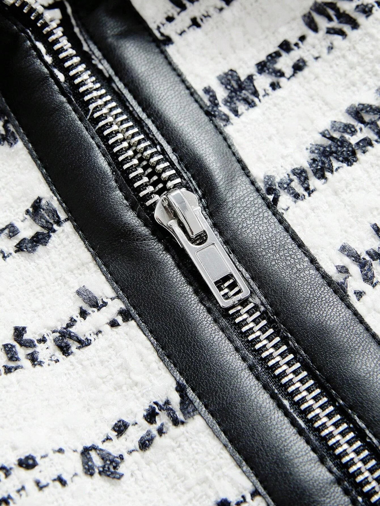This stylish dress features a chic black and white design with intricate patterns, accentuated by a glossy black zipper that.