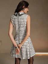 This stylish sleeveless dress features a sophisticated black and white striped pattern, tailored to create a flattering.