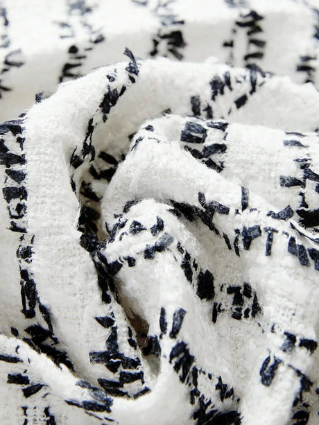 The dress features a chic black and white pattern with a textured fabric that offers a soft, cozy feel. Its relaxed fit.