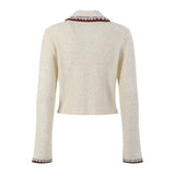 Elegant cream tweed jacket with red and black embroidery, decorative buttons, and a tailored fit