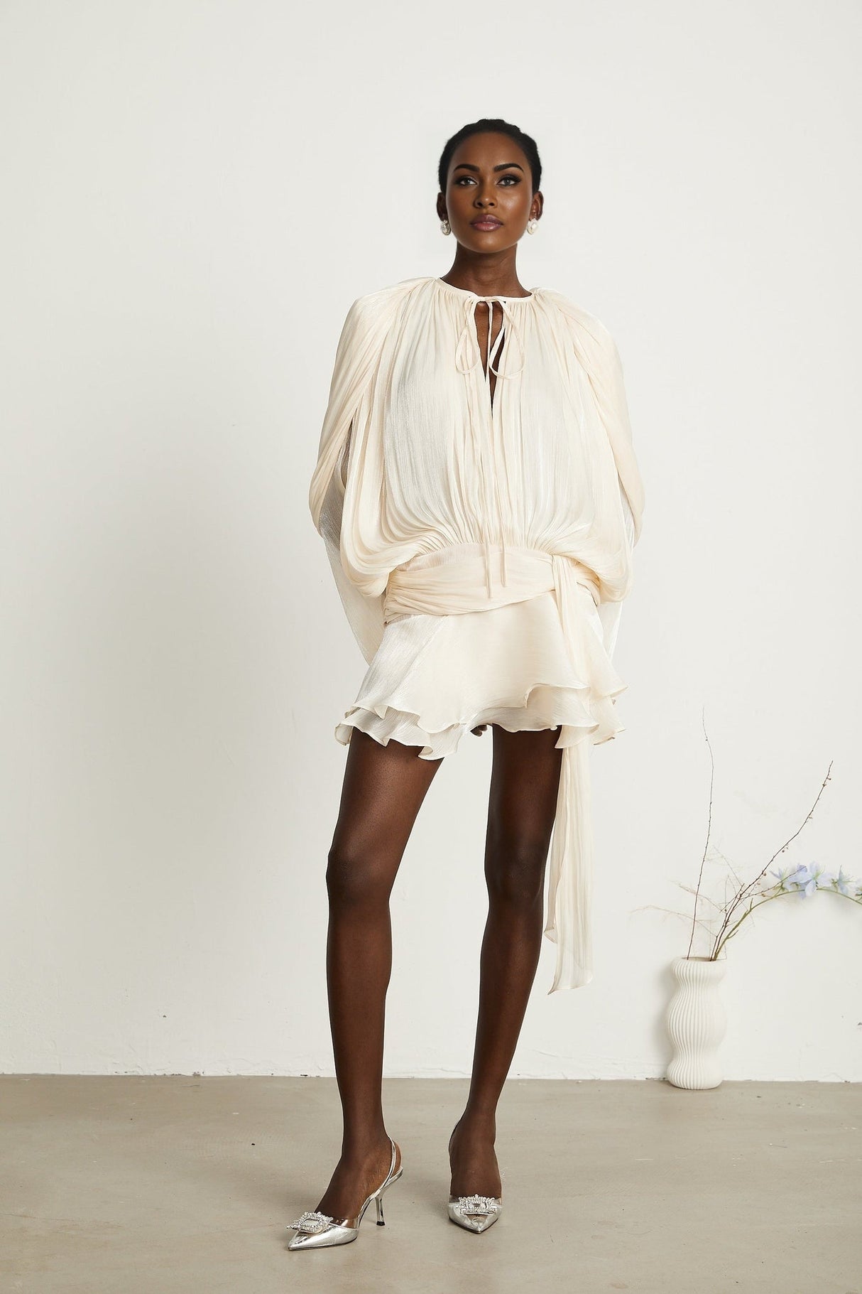 Eugenie pleated ruffled mini dress in neutral color with voluminous skirt and short length