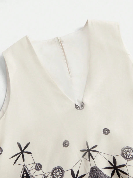 This elegant cream dress features a sophisticated V-neckline and delicate black embroidery, showcasing an intricate design.