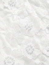 Elegant white dress featuring intricate floral embroidery and delicate pearl accents, creating a romantic and feminine.