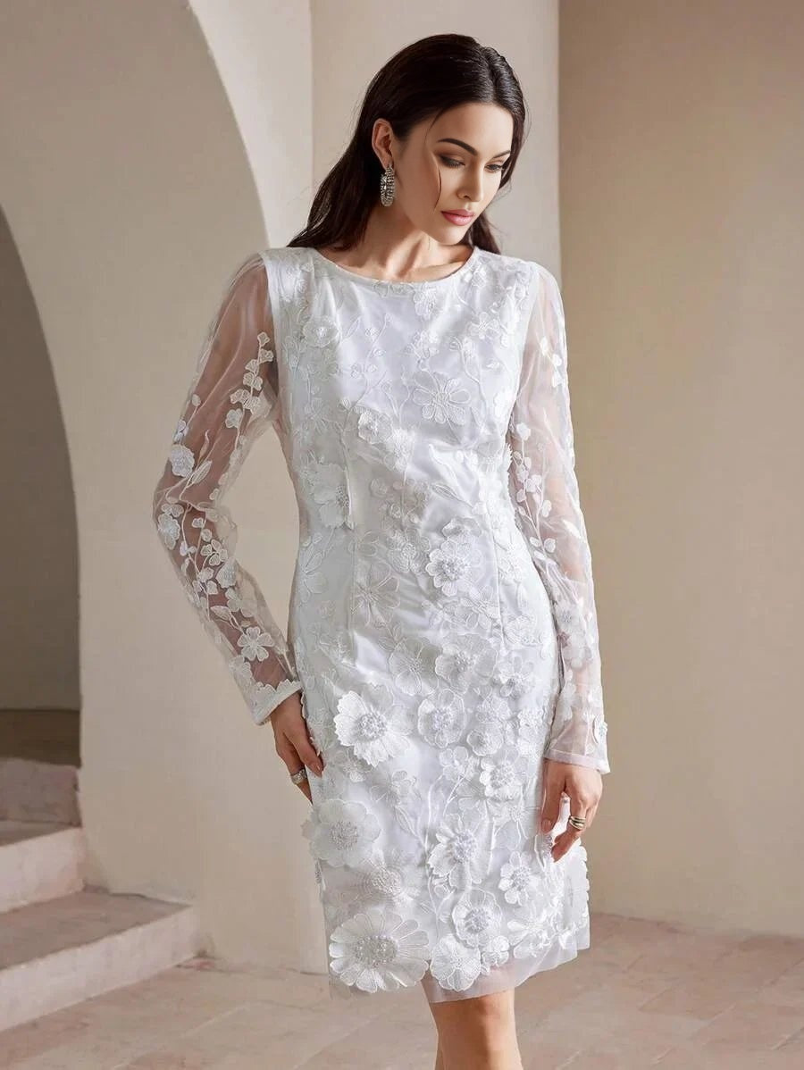 Elegant and intricately designed, this white dress features long sheer sleeves adorned with delicate floral embroidery,.