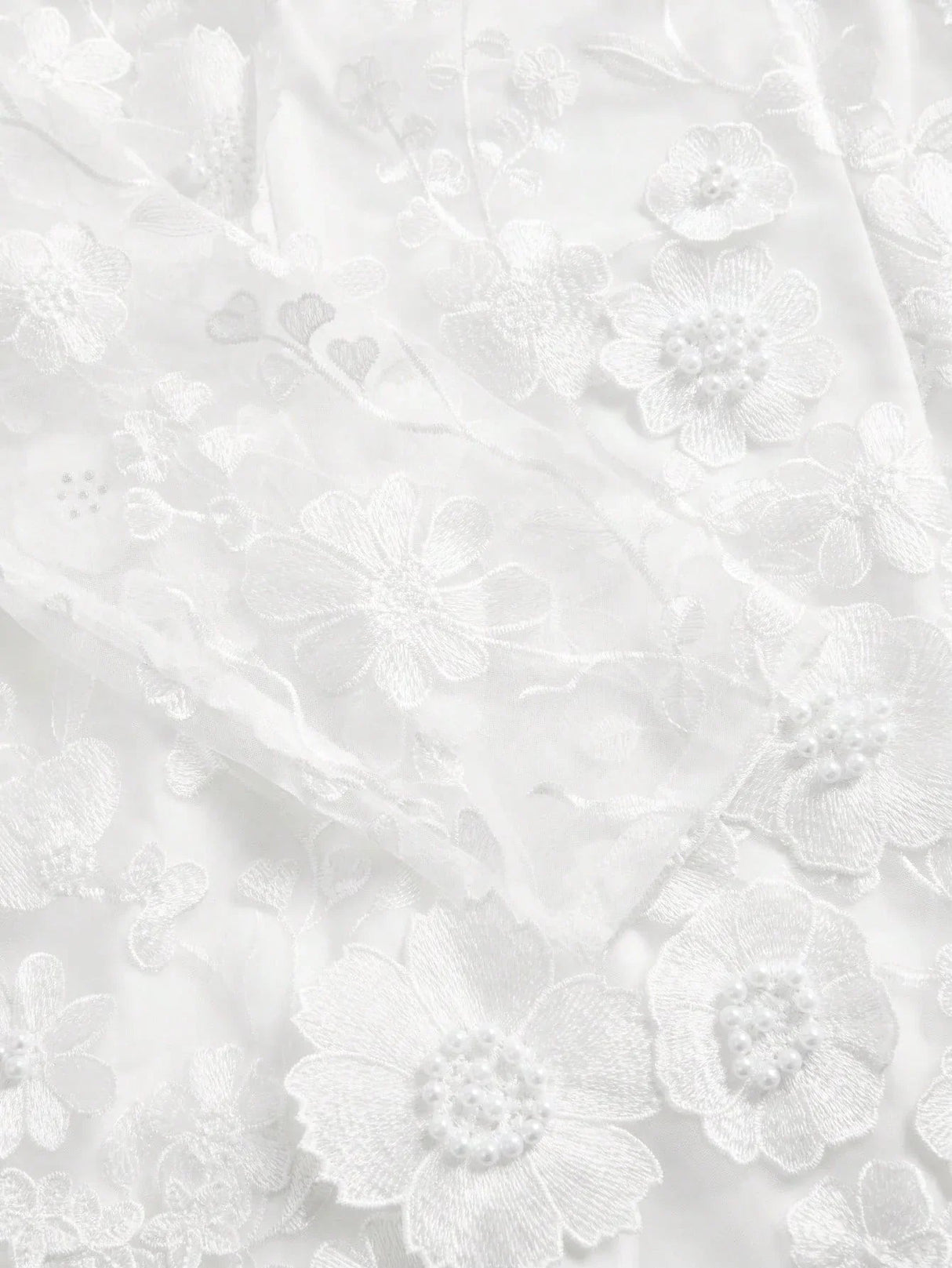 Delicate and ethereal, this stunning white dress features intricate floral embroidery adorned with pearl accents, creating a.