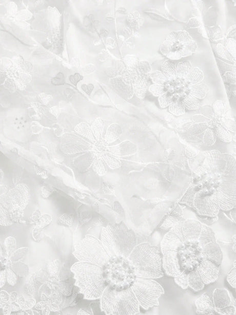 Delicate and ethereal, this stunning white dress features intricate floral embroidery adorned with pearl accents, creating a.