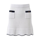 White knit cardigan with navy accents and gold buttons paired with a matching A-line skirt featuring a flared hem
