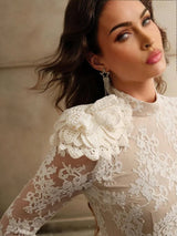 This elegant, ivory lace dress features a fitted silhouette that enhances the figure and is beautifully accented by a large,.