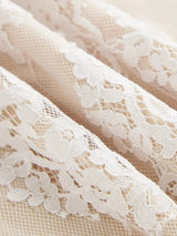 Delicate white lace features intricate floral patterns, lending a romantic touch to this elegant dress fabric. The.