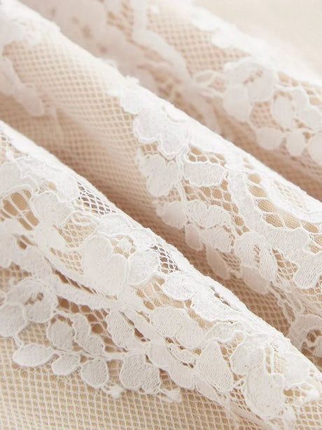 Delicate white lace features intricate floral patterns, lending a romantic touch to this elegant dress fabric. The.