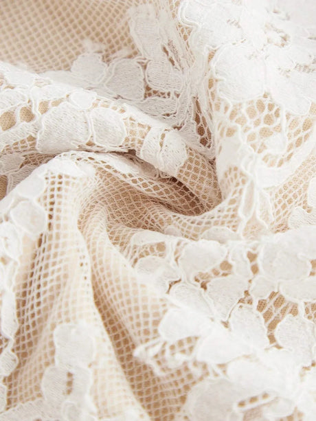 Delicate cream lace fabric with intricate floral patterns creates a romantic and ethereal look, perfect for a summer dress..