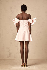 Image of a short pink mini dress with an offshoulder neckline featuring three dimensional floral petal details covering the bodice named Juliette
