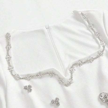 This elegant white dress features a delicate floral beaded neckline that adds a touch of sparkle, perfect for special.