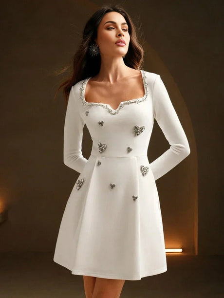 This elegant white dress features a flattering fitted bodice and a playful flared skirt, adorned with sparkling heart-shaped.