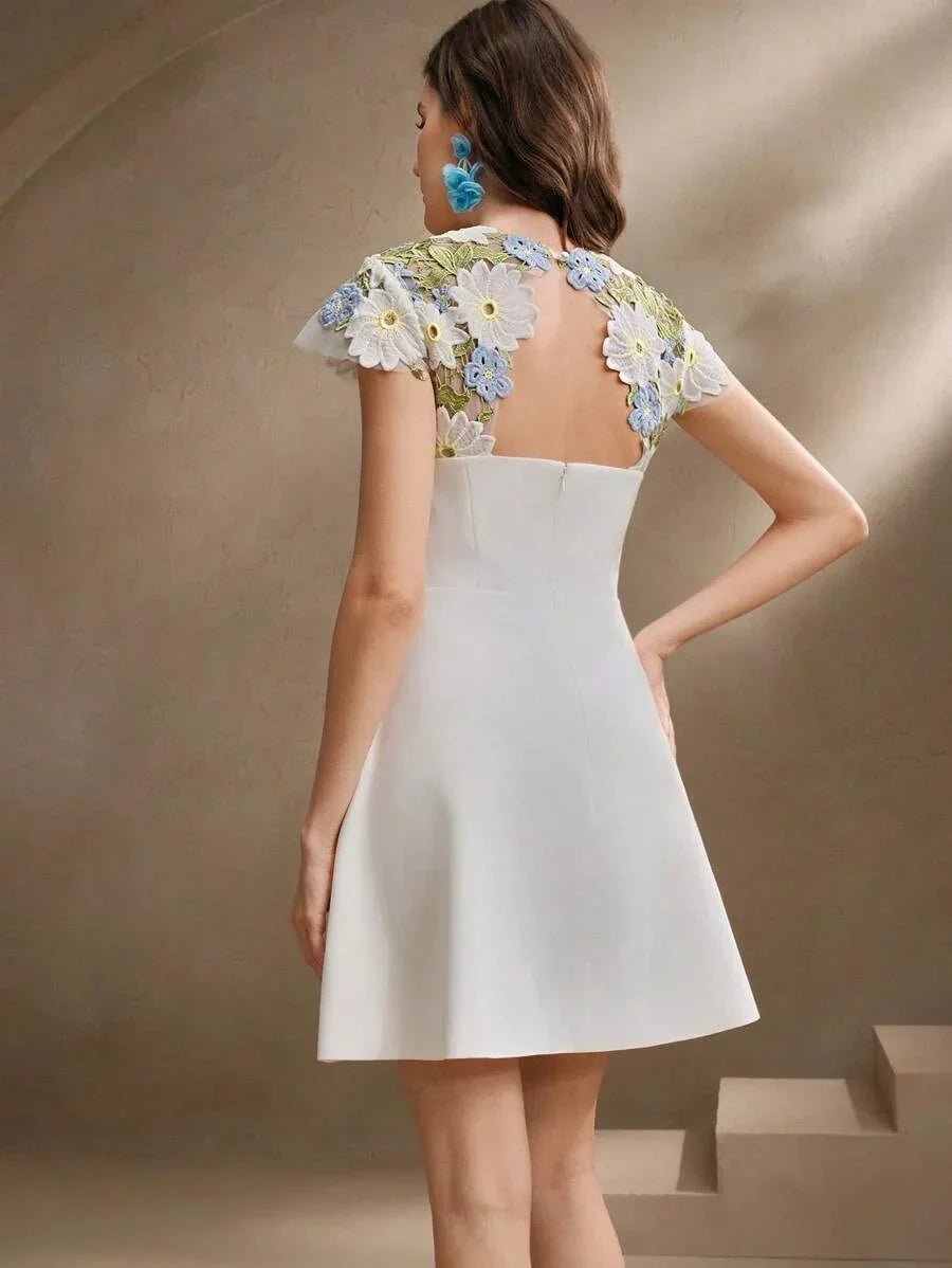 This charming white dress features a flared silhouette, highlighted by delicate floral embroidery on the cap sleeves and.