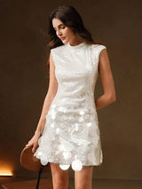 This stunning white dress features a sleek, fitted silhouette with a high neckline and cap sleeves, adorned with shimmering.