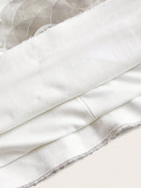 A soft white dress featuring a sleek, fitted bodice and delicate lace trim along the hem, perfect for both casual outings.