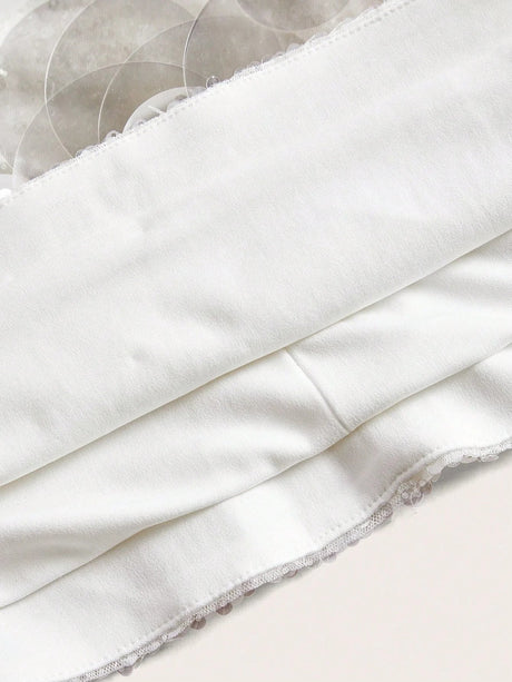 A soft white dress featuring a sleek, fitted bodice and delicate lace trim along the hem, perfect for both casual outings.