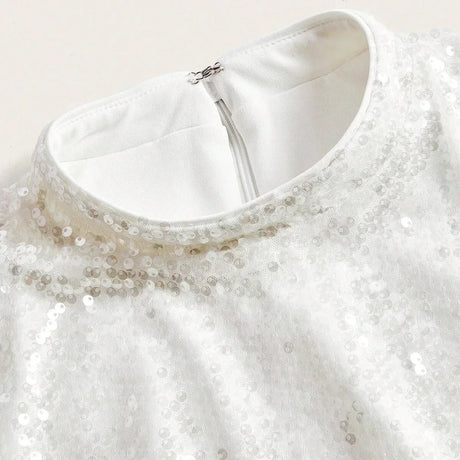 Elegant and shimmering, this white dress features a subtle sequin overlay that catches the light beautifully, adding a touch.