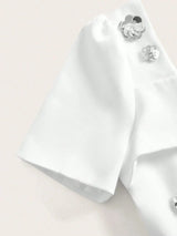 Elevate your wardrobe with this elegant white dress featuring short sleeves adorned with delicate floral embellishments..