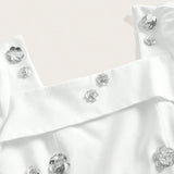 This elegant white dress features delicate silver flower embellishments that add a touch of glamour to its chic design. The.