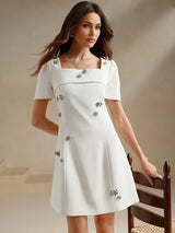This elegant white dress features a chic square neckline and short sleeves, exuding a timeless charm perfect for any.