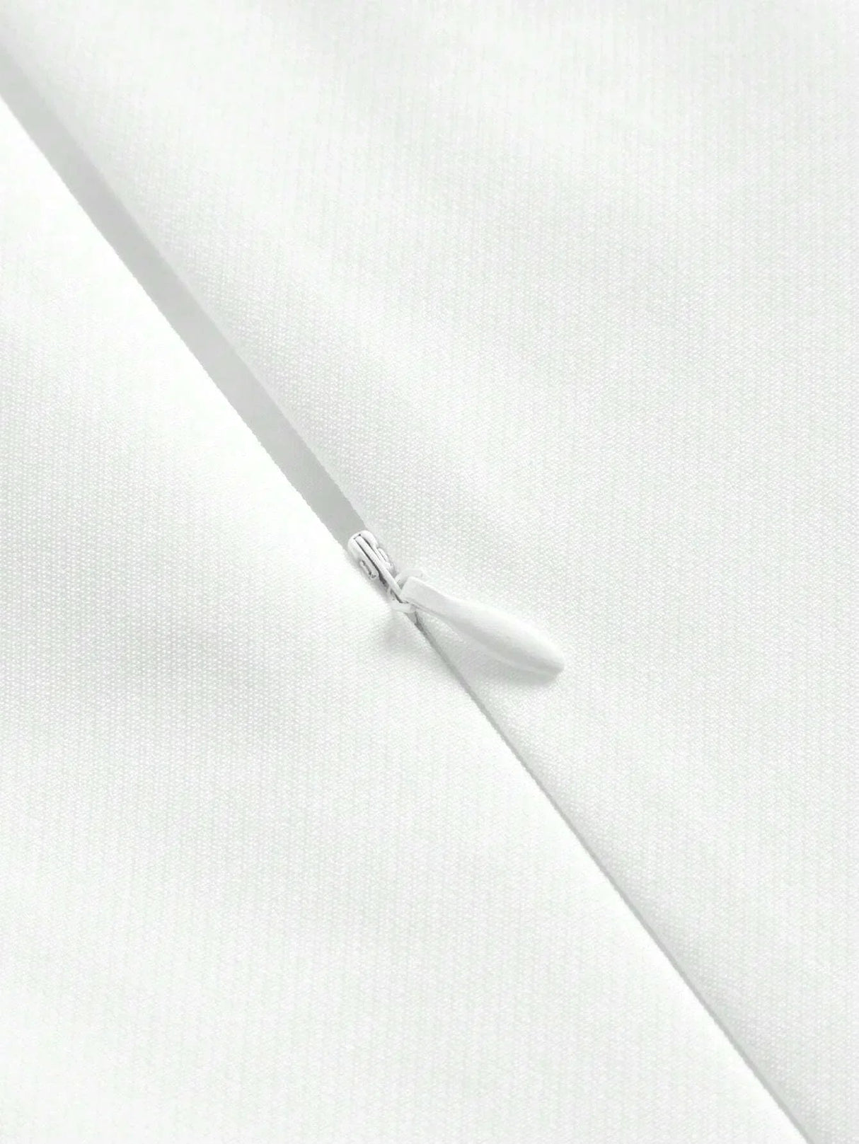This elegant white dress features a sleek, fitted silhouette and a zipper closure for added convenience, showcasing a.