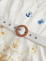 This charming white dress features delicate floral prints in soft pastel hues, complemented by elegant blue pansy accents..
