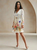 This charming white dress features a delicate floral print in vibrant shades of pink and blue, accentuating its feminine.