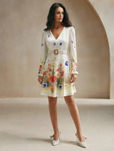 A charming cream dress adorned with colorful floral patterns, featuring a flattering V-neckline and elegant long sleeves..