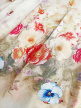 This flowing dress features a delicate, pastel floral print with vibrant hues of red, pink, and blue, creating an enchanting.